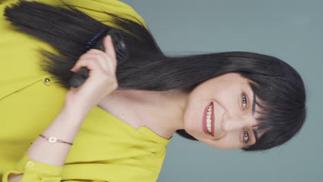 Vertical-video-of-Woman-combing-her-hair.